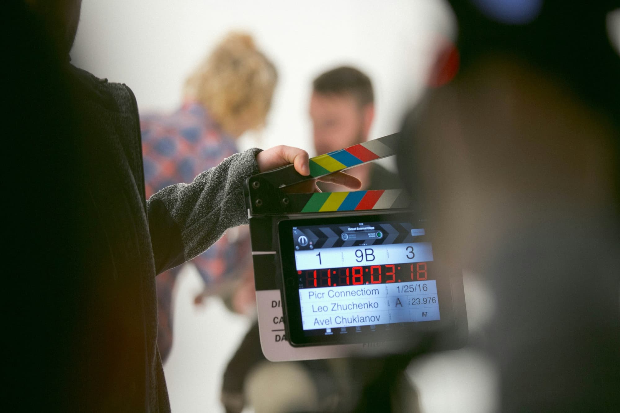 Hand hält eine Filmklappe am Set